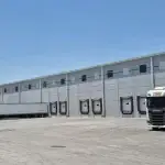 Exterior de bodega industrial con 8 andenes de carga, área de maniobras y estacionamiento para trailers
