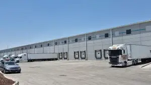 Exterior de bodega industrial con 8 andenes de carga, área de maniobras y estacionamiento para trailers