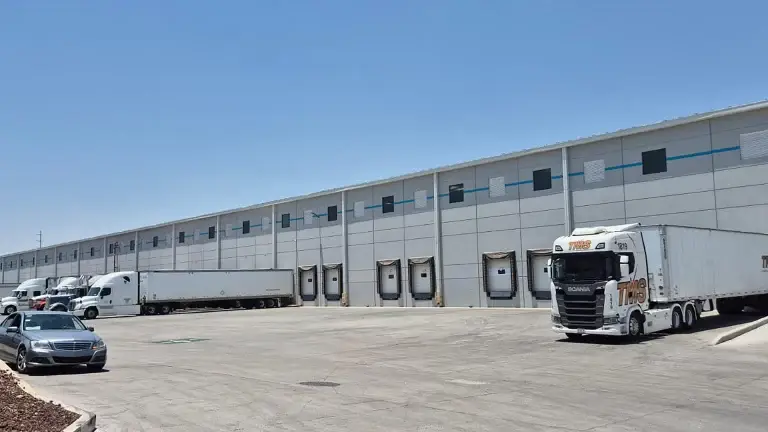 Exterior de bodega industrial con 8 andenes de carga, área de maniobras y estacionamiento para trailers